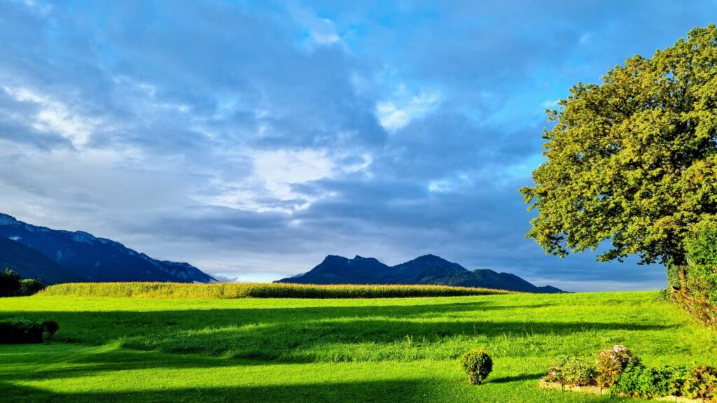 Berglandschaft der Aschauer Alpen bei bewölktem Himmel und kräftigem Sonnenlicht